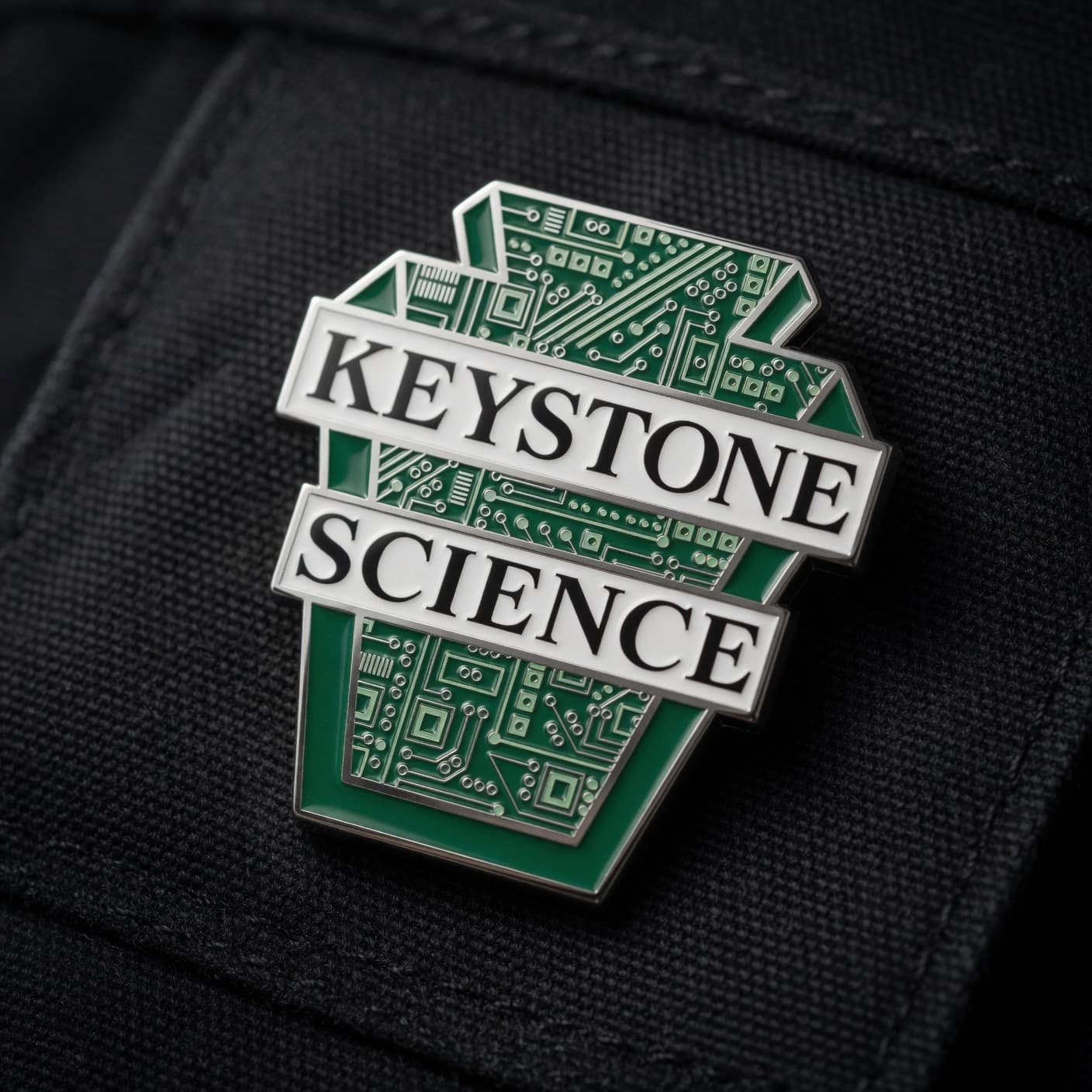 Keystone Science logo pin on dark fabric